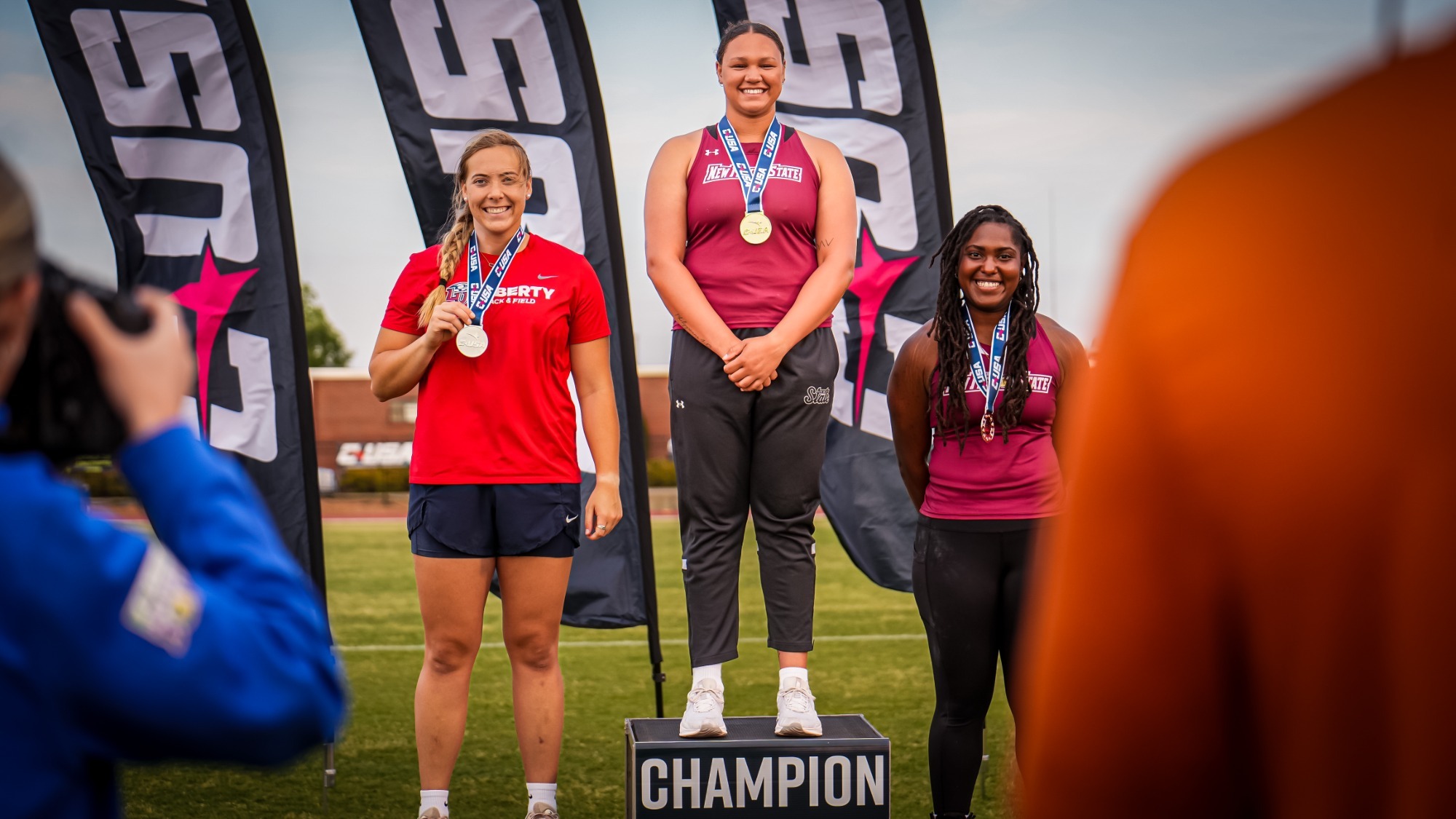 Alesha Lane standing on the Champion podium at the 2026 CUSA Outdoor T&F Championships 