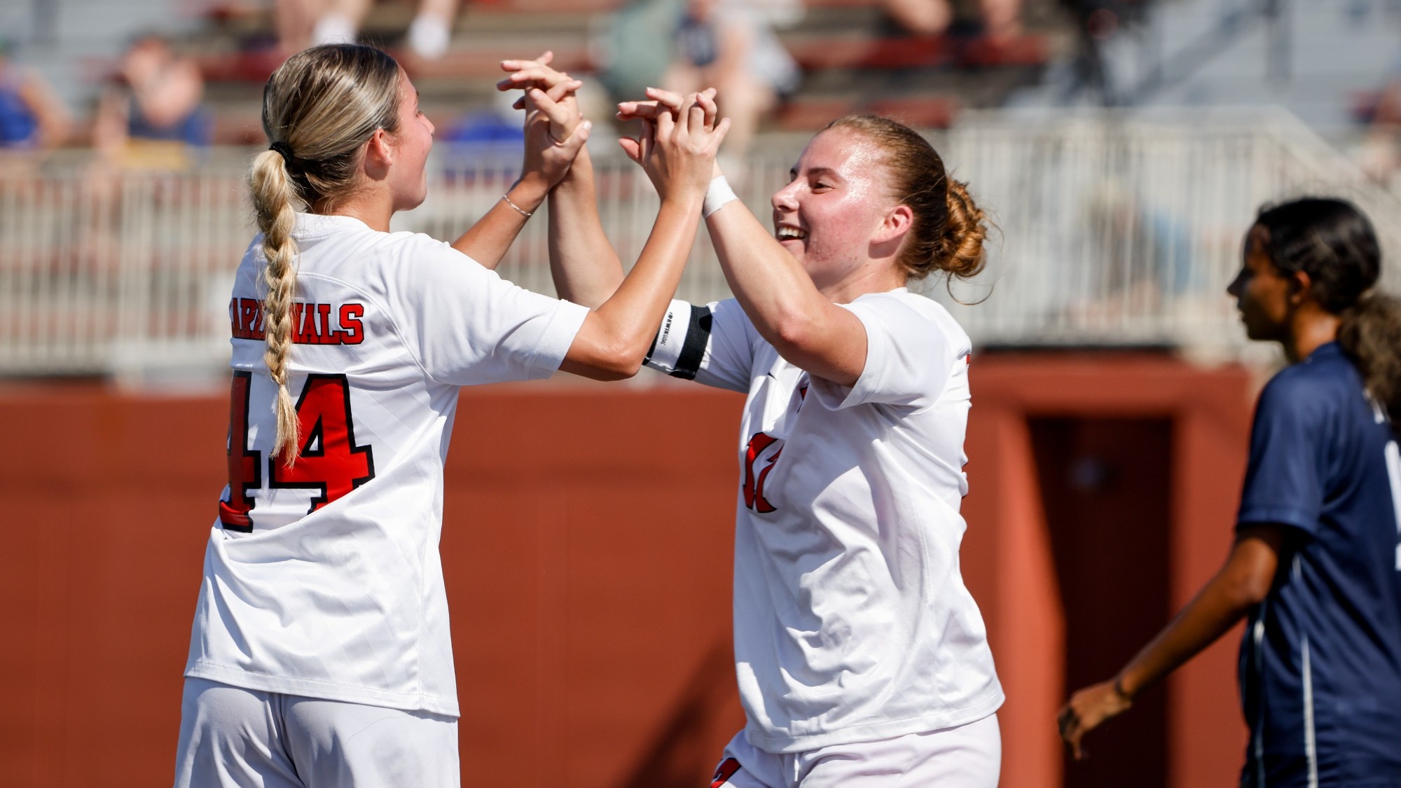 Jordan Lange and Madison DeVriendt high-five after a goal
