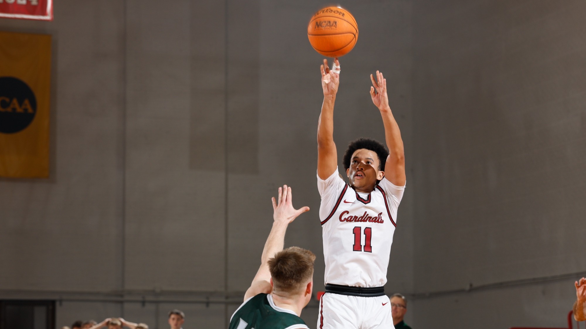Tre Davis shooting a three pointer over an Illinois Wesleyan defender