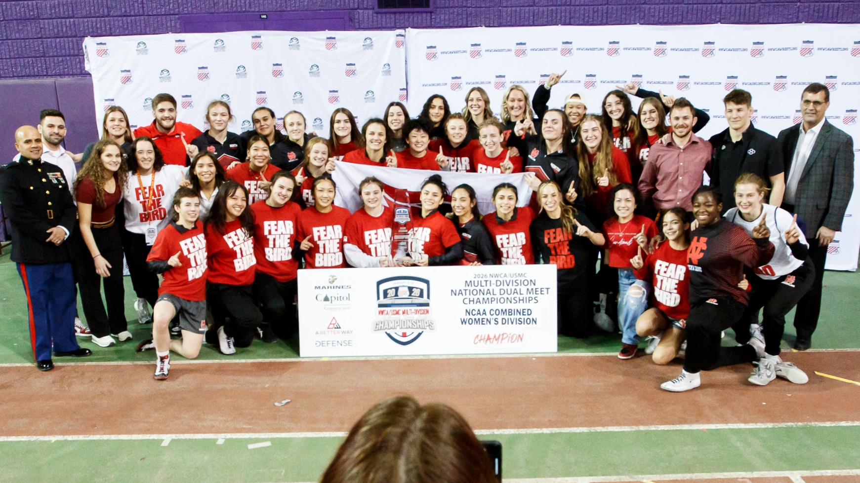 Women's Wrestling with NWCA National Duals trophy and banner