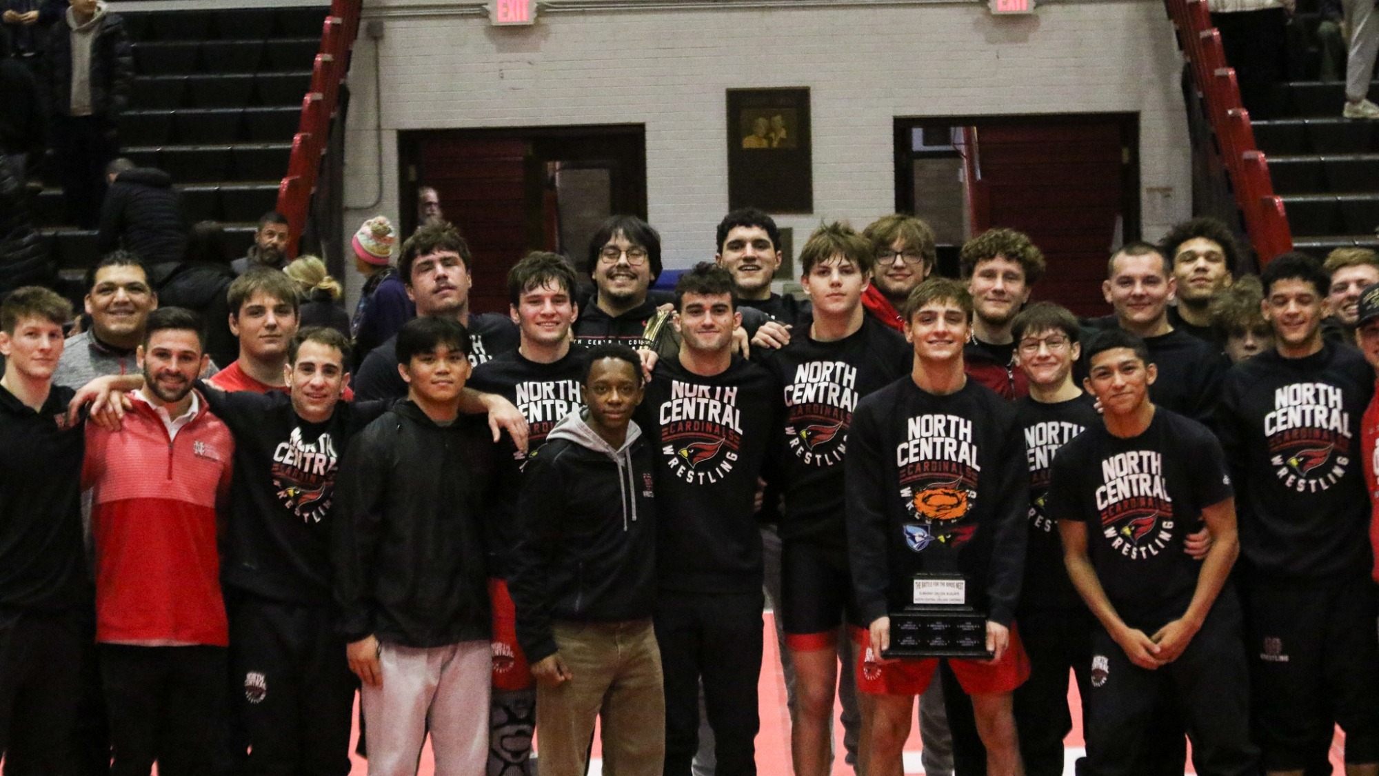 North Central Men's Wrestling poses with trophy