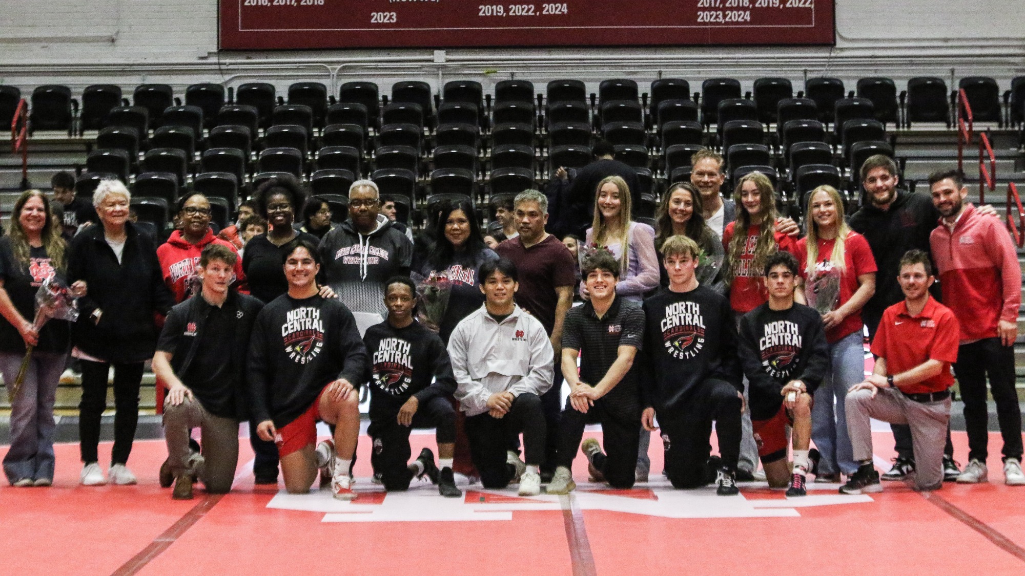 Cardinals Honored on Senior Night posing in the middle of the mat