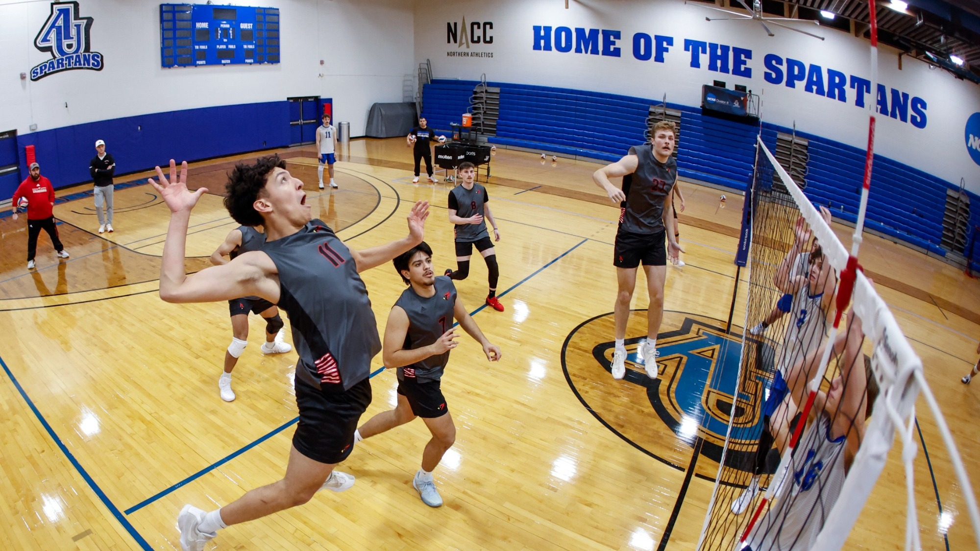 Elijah Landeros leaps to make an attack while three athletes leap in an attempt to block it. 