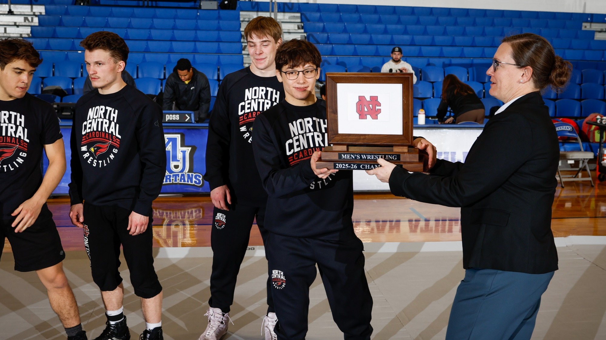 Ethan Spacht accepts the conference regular season plaque from the conference comissioner