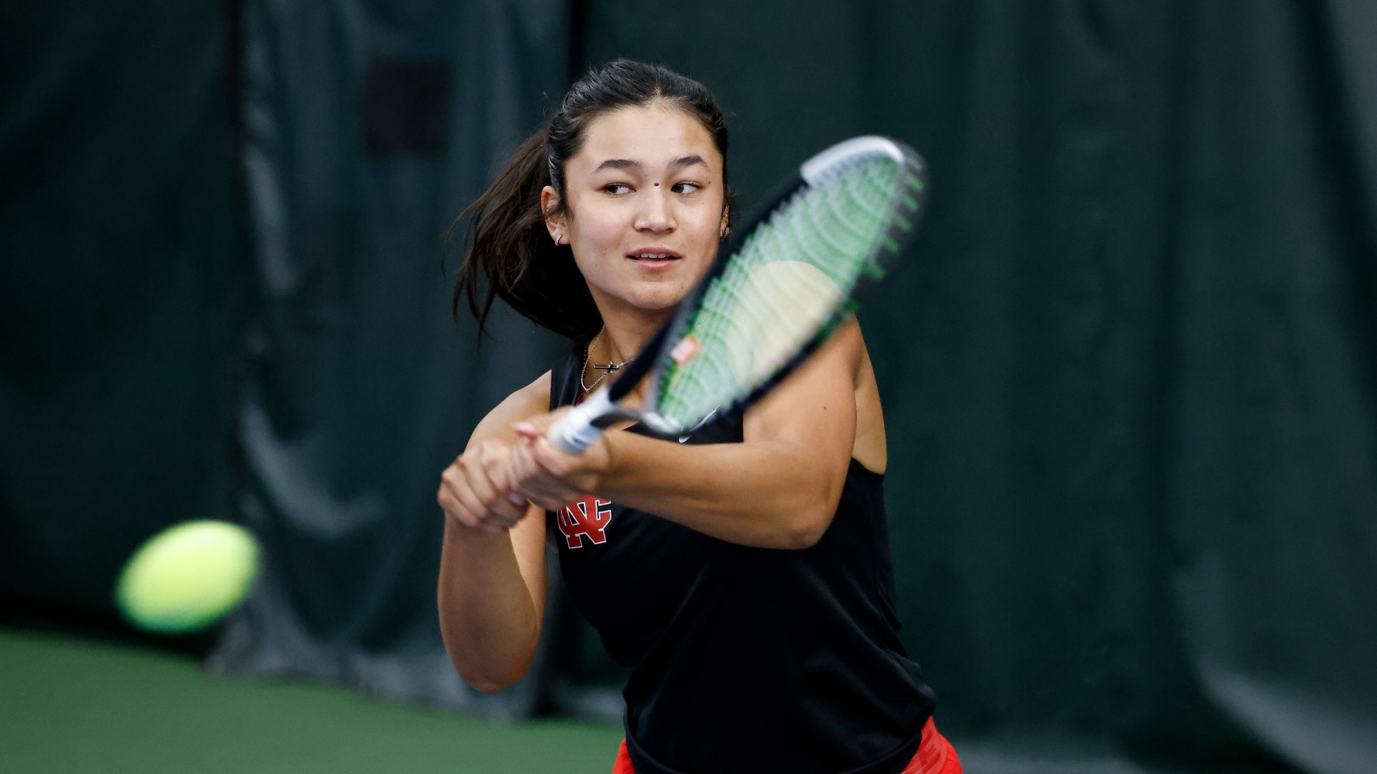 Berkley Klarich watches the ball closely as she makes a backhanded swing during a tennis practice.