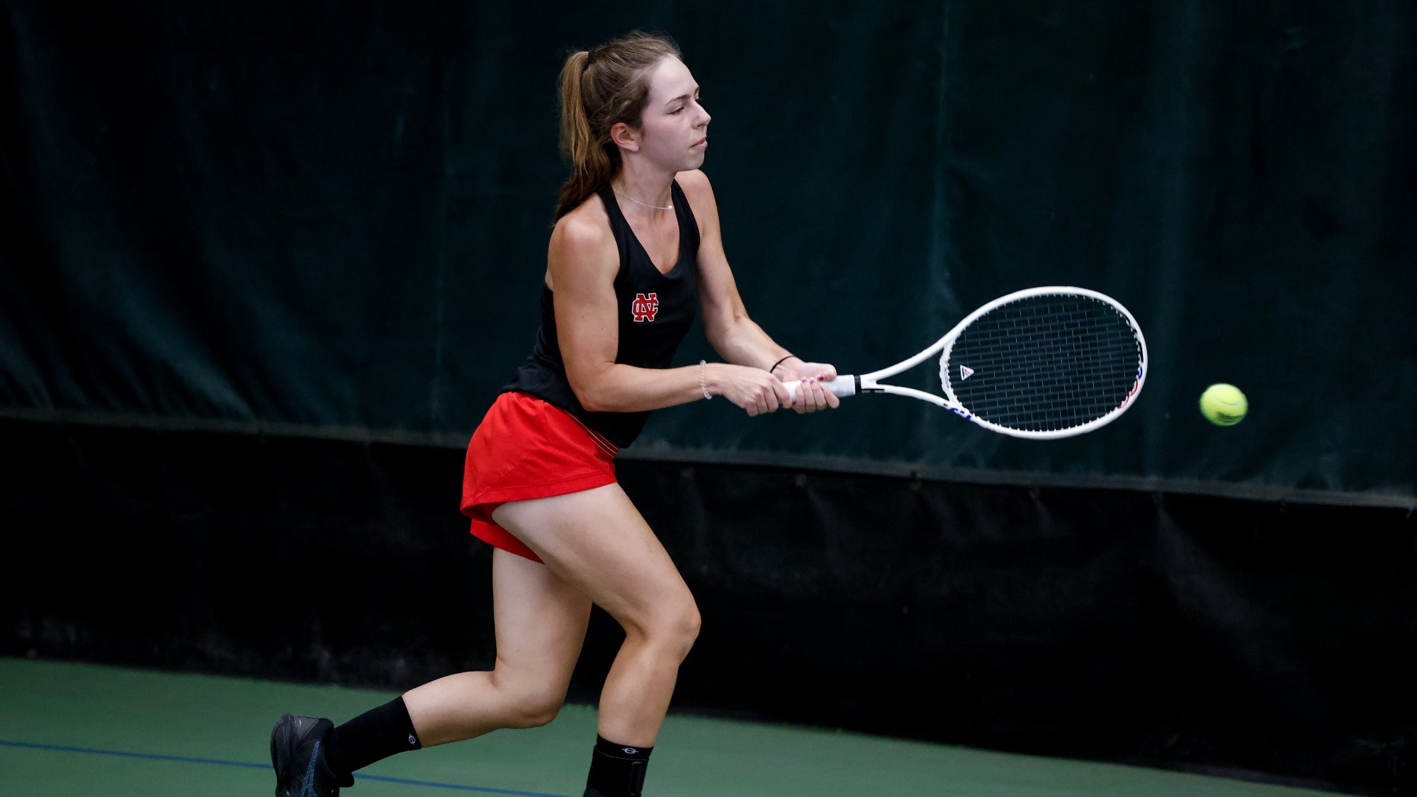 Kate Herlihy chases down a ball and delivers a backhanded swing during a practice.