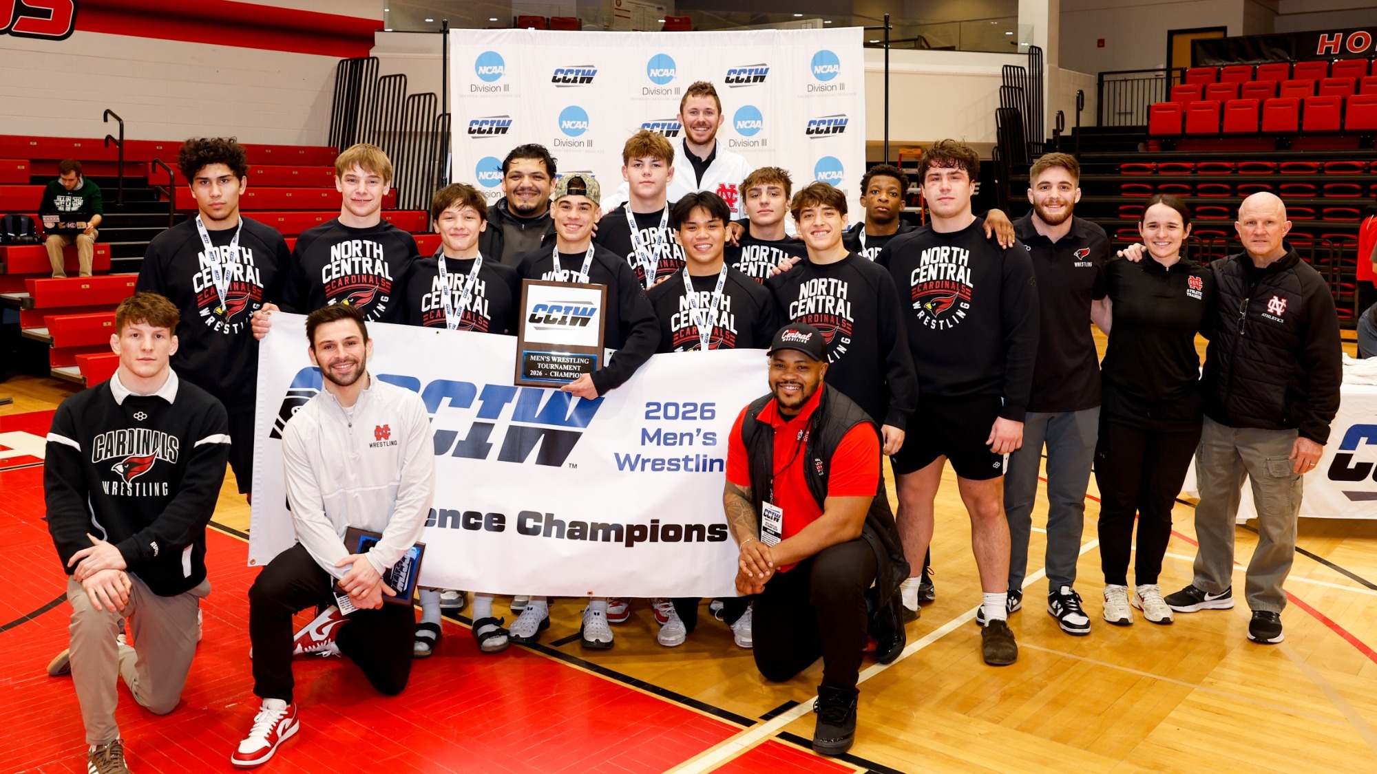 Men's Wrestling poses with CCIw Tournament Championship Banner
