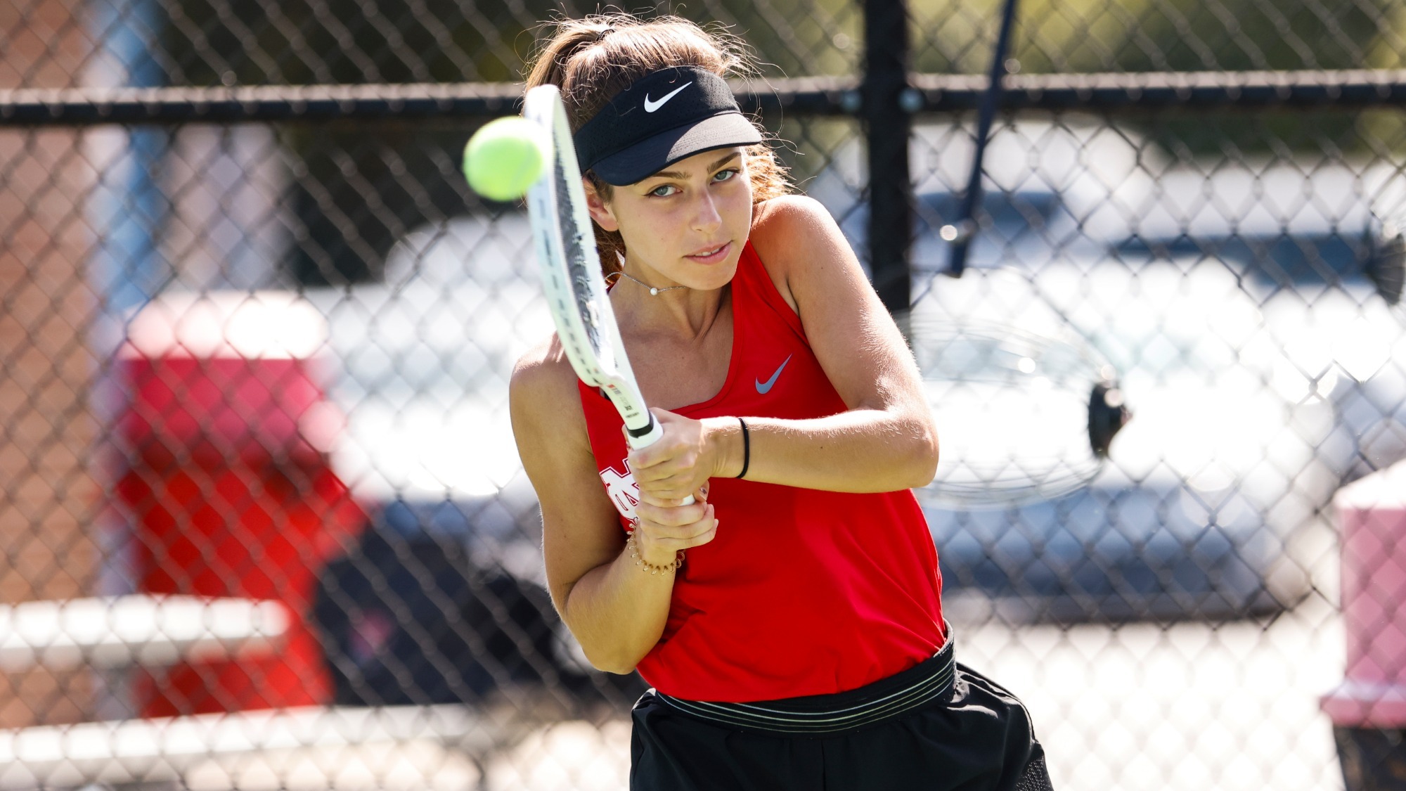 Kate Herlihy follows through after using a backhand swing during a tennis match