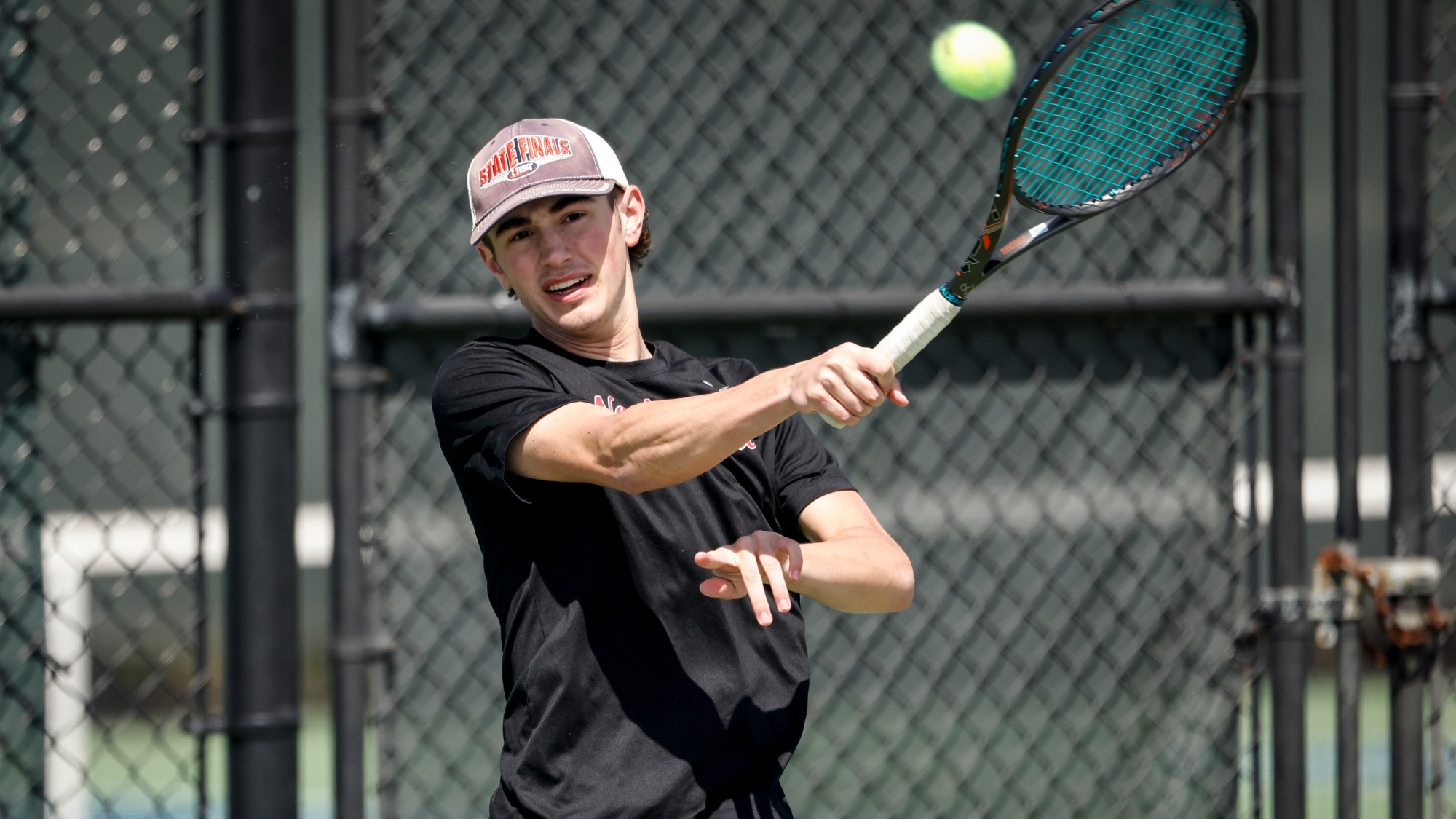Brandon Paasch follows through after hitting a tennis shot using a forehand stroke.