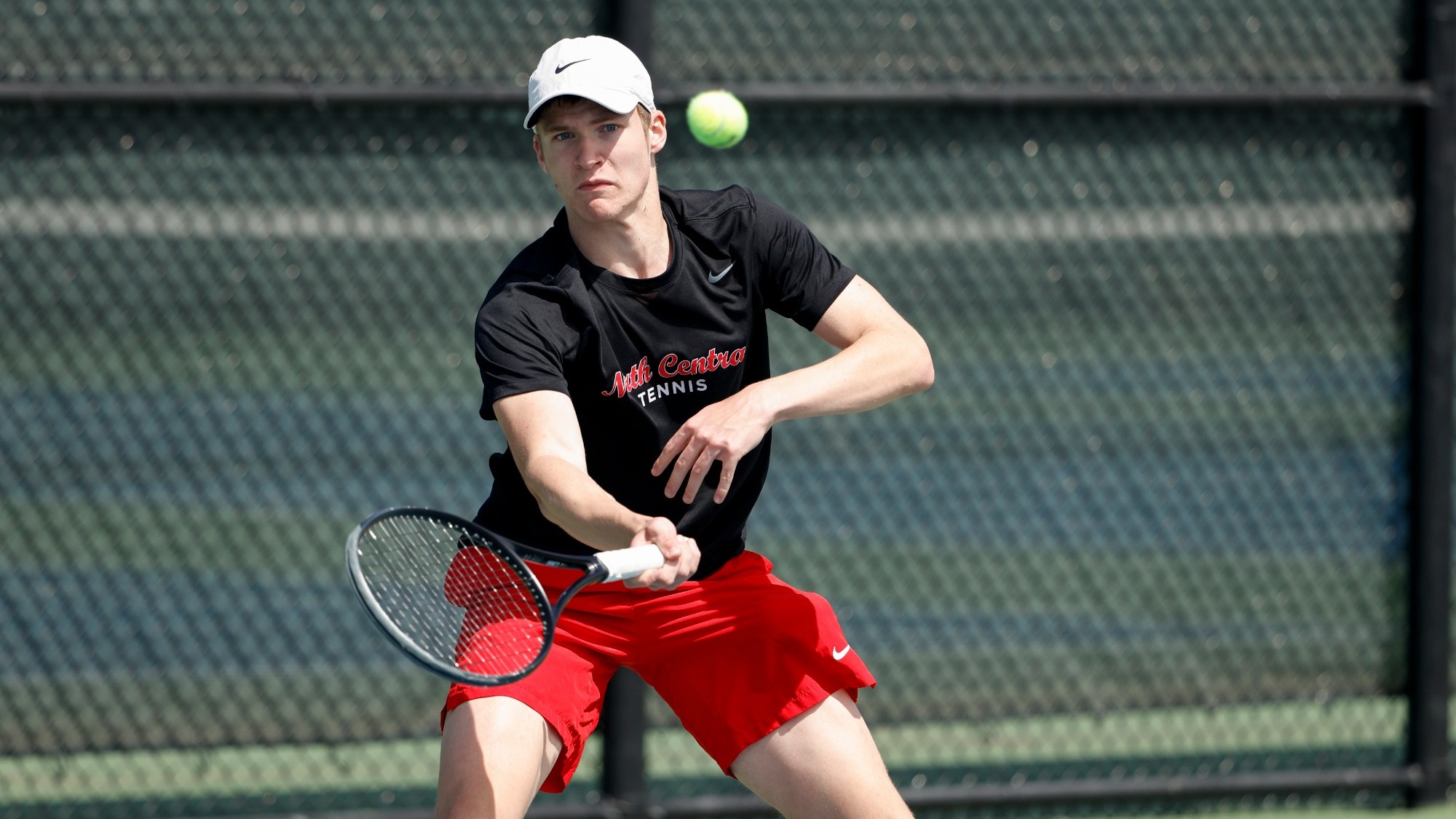 Philipp Wottgen follows through using a forehand swing in a tennis rally.
