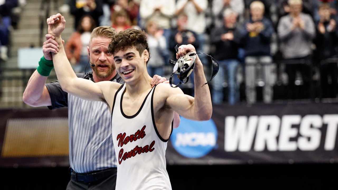 Chip Guzman celebrates winning a national championship with his hand raised