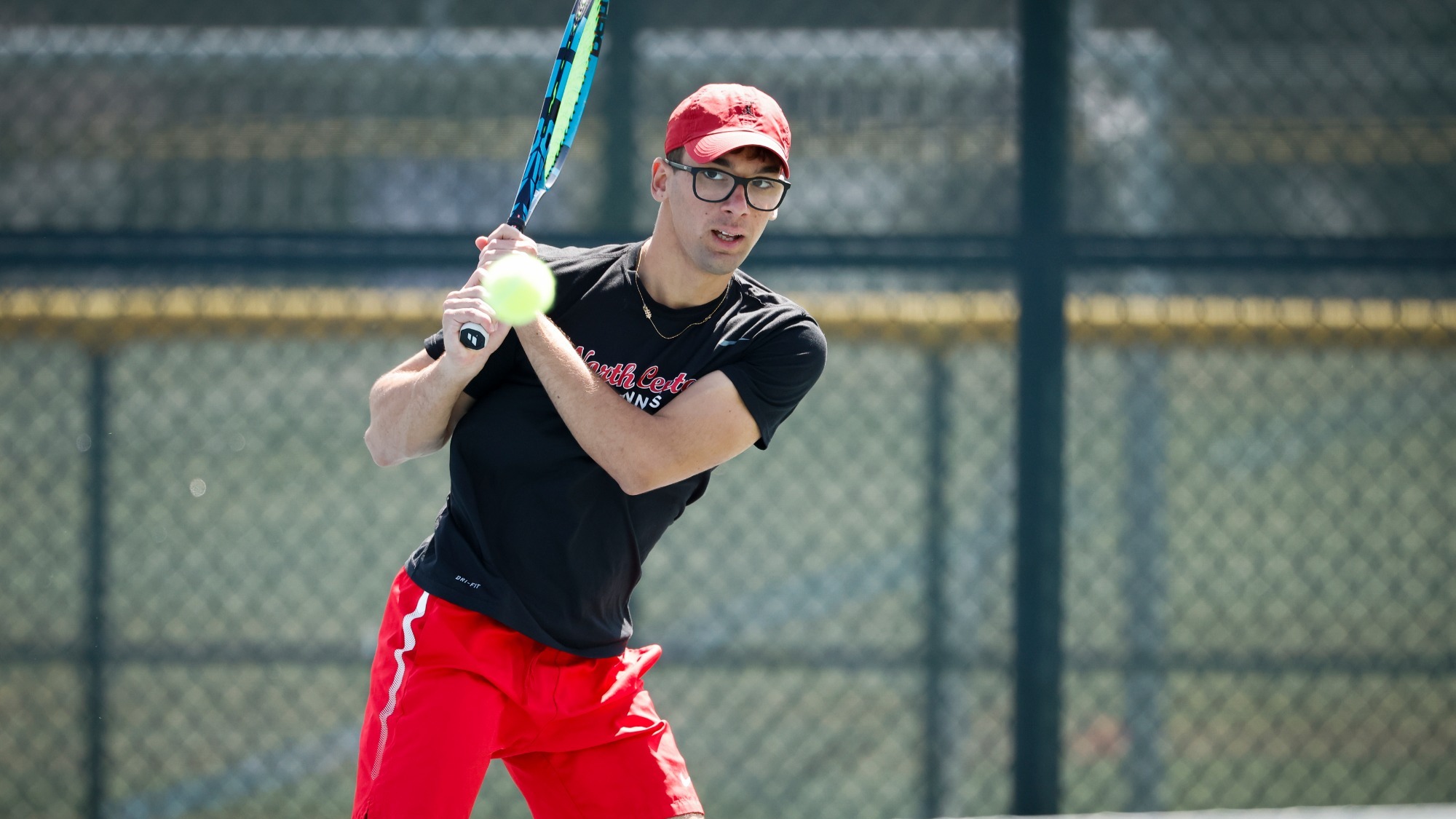 David Vilarroig Martinez holds his finish after hitting a backhanded shot during a tennis match. 