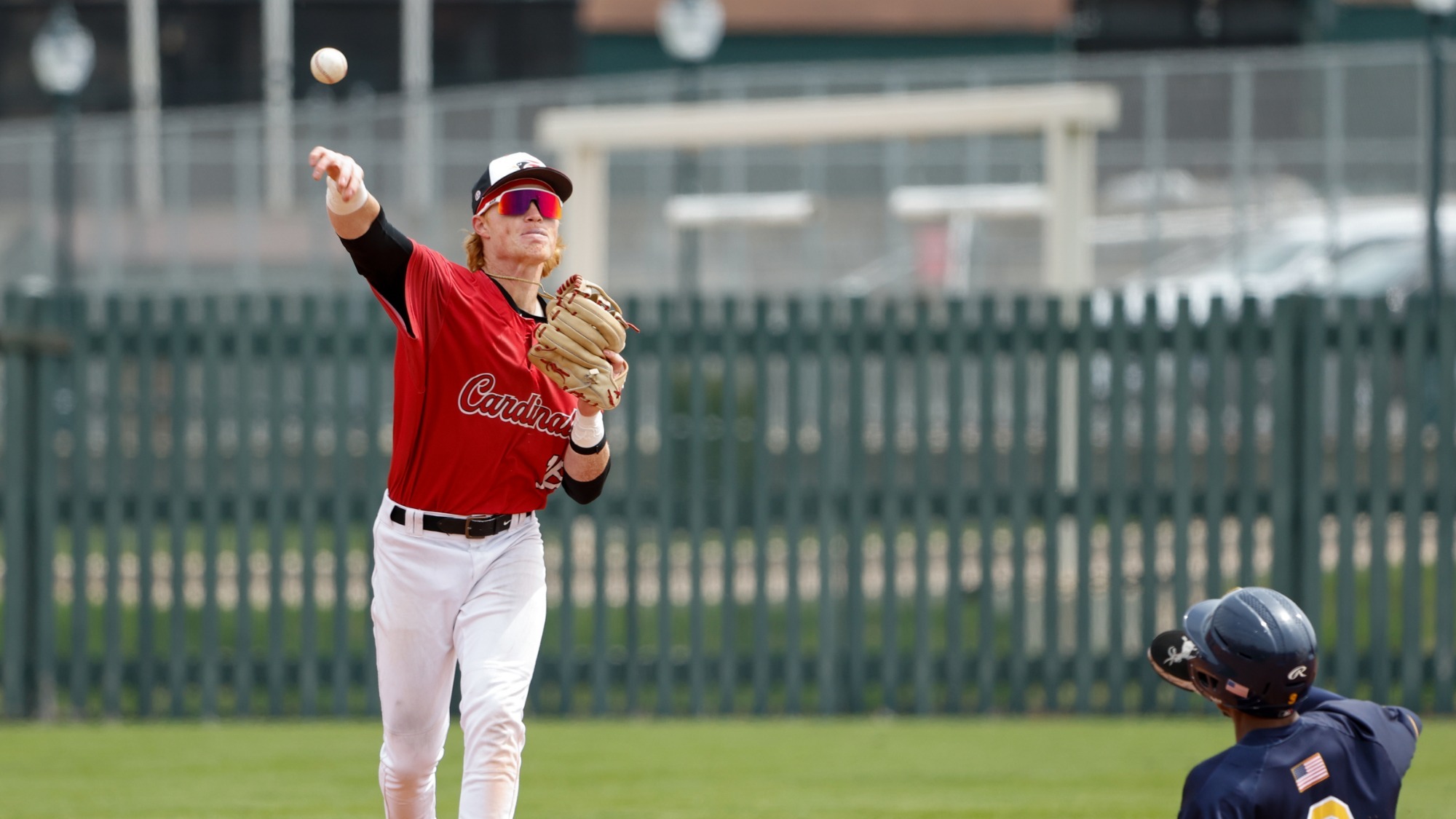 Jackson Bland throwing from second base to first base on a double play attempt