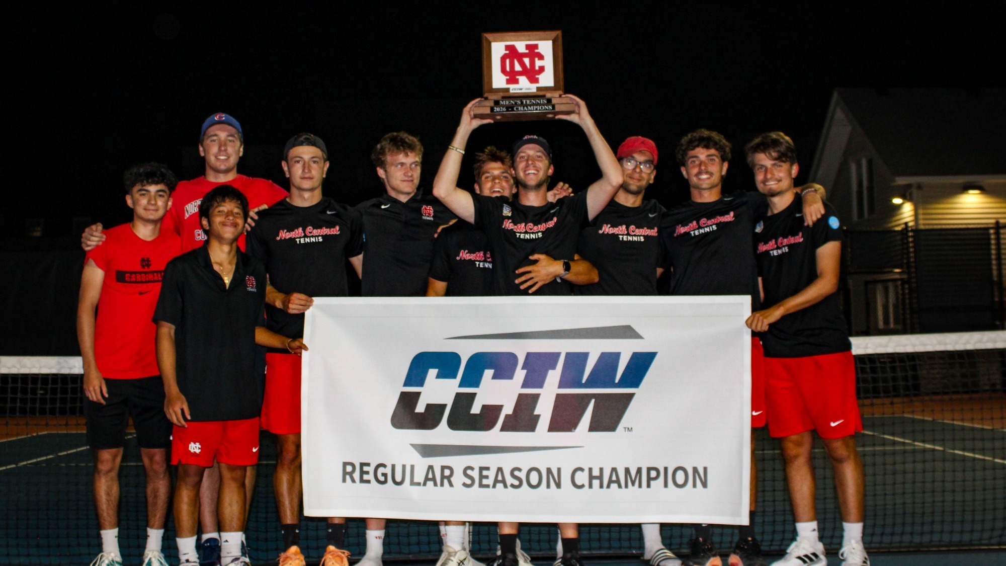 The 2026 Men's Tennis poses with the 2026 CCIW Championship banner and plaque