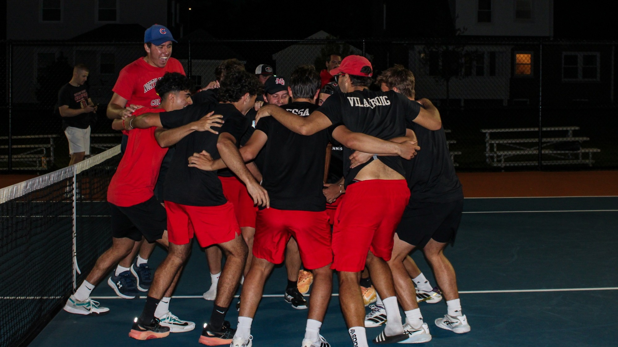 Men's Tennis Celebrates Conference Title by embracing in large group hug