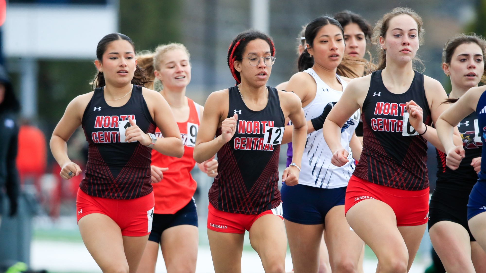 North Central women's distance runners in a group on the home stretch