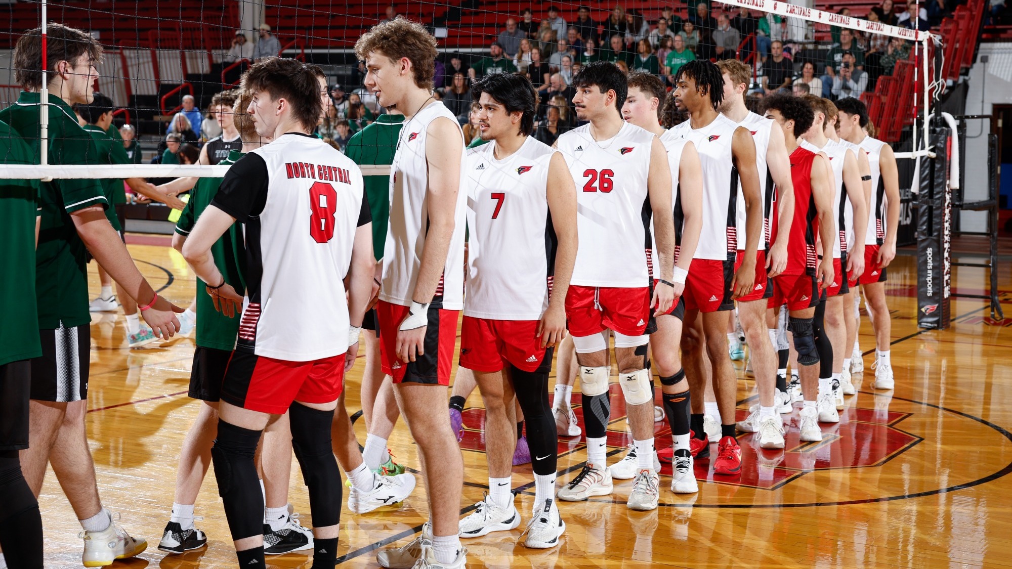 North Central men's volleyball players line up at the net to shake the hands of their opponents before a match