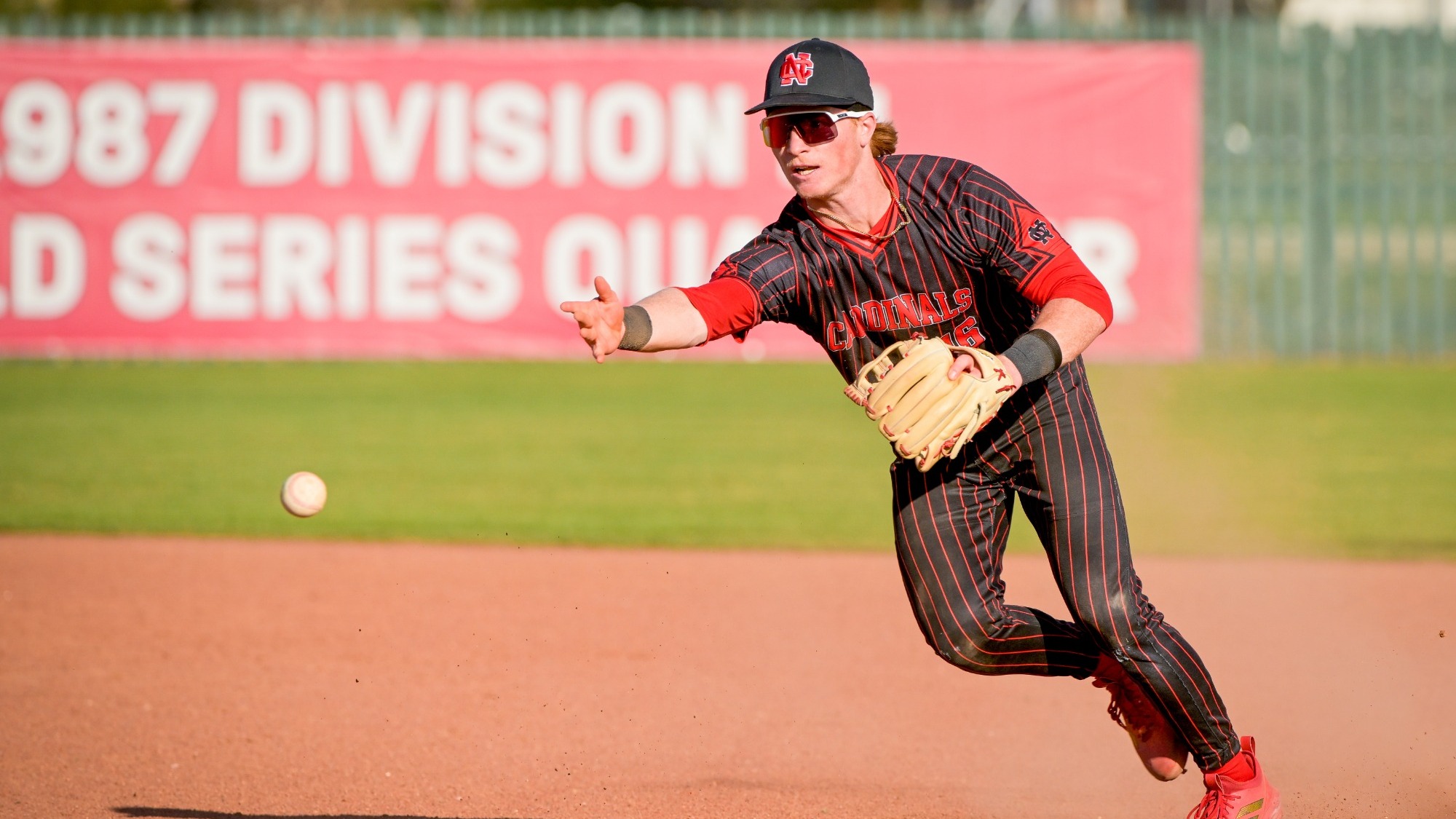 Jackson Bland tossing a baseball to first base
