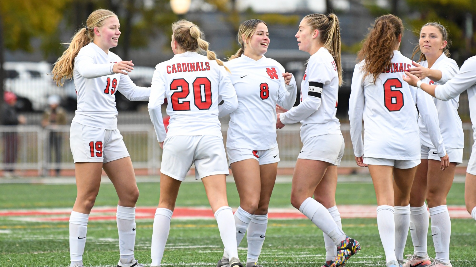 Women's soccer huddles after a goal