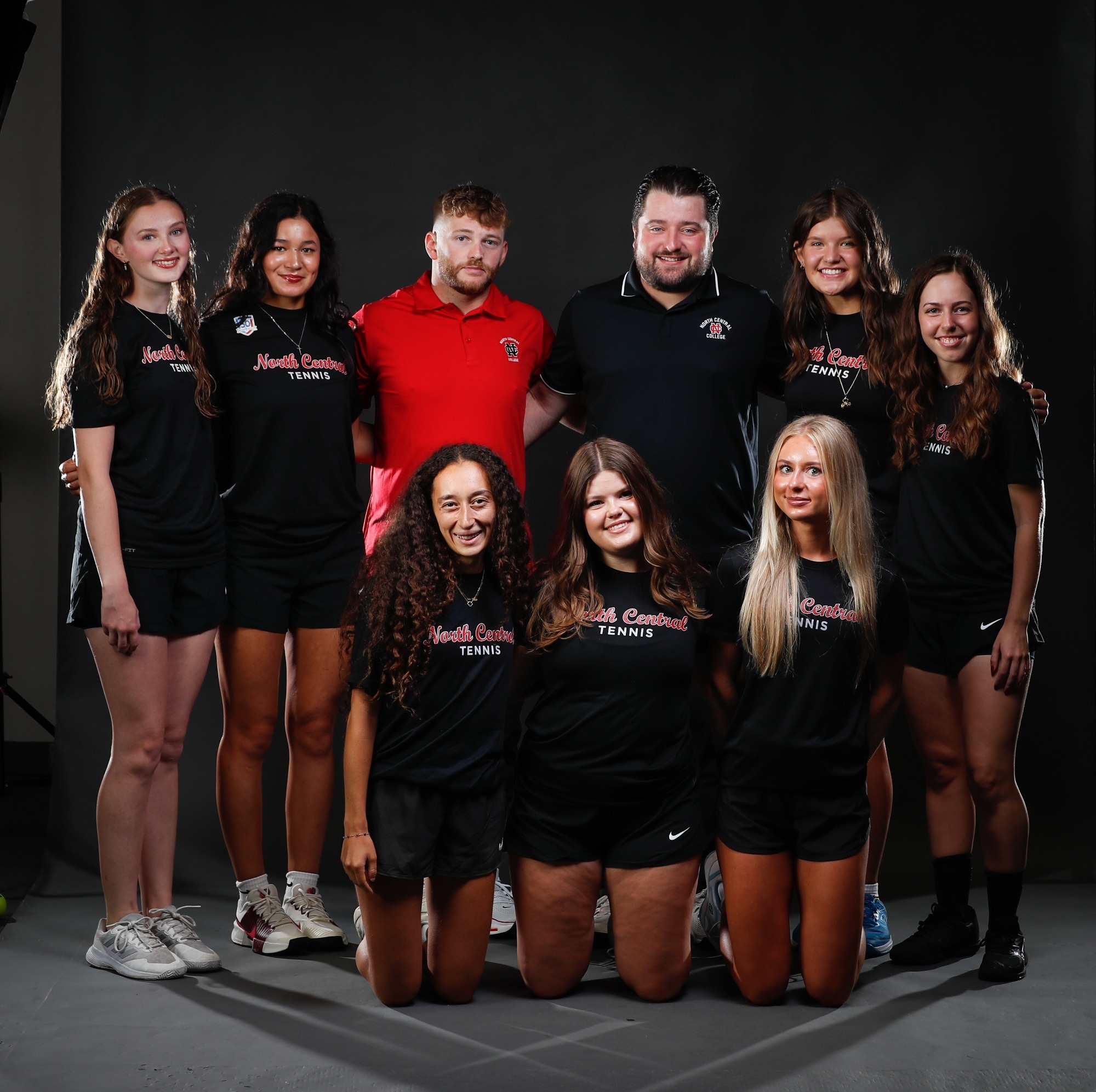 The members of the women's tennis team and its coaches pose for a picture.
