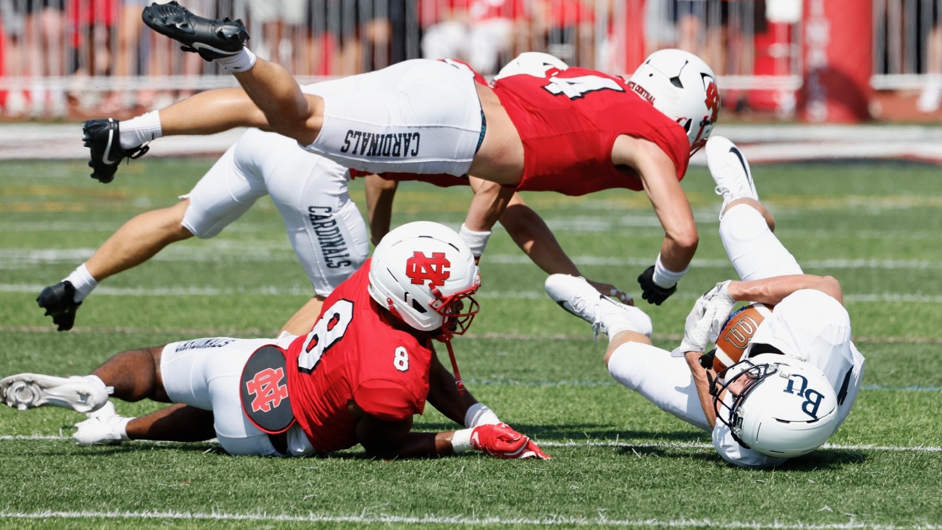 Ethan Groark and Kyler Green dive at the opposing quarterback as they tackle him