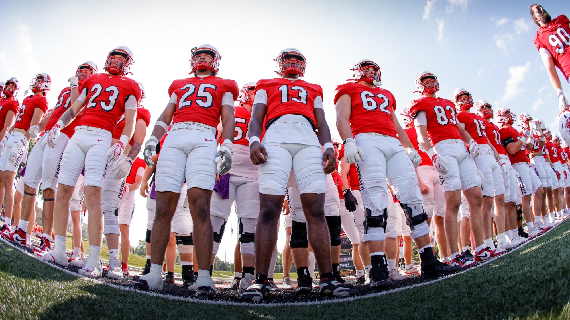 Members of the North Central Football Team stand in a line waiting to run out onto the field.