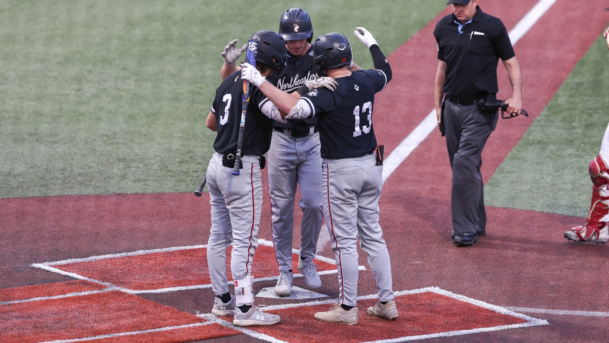 Harrison Feinberg celebrates his program-record-tying home run with Matt Brinker and Ryan Gerety