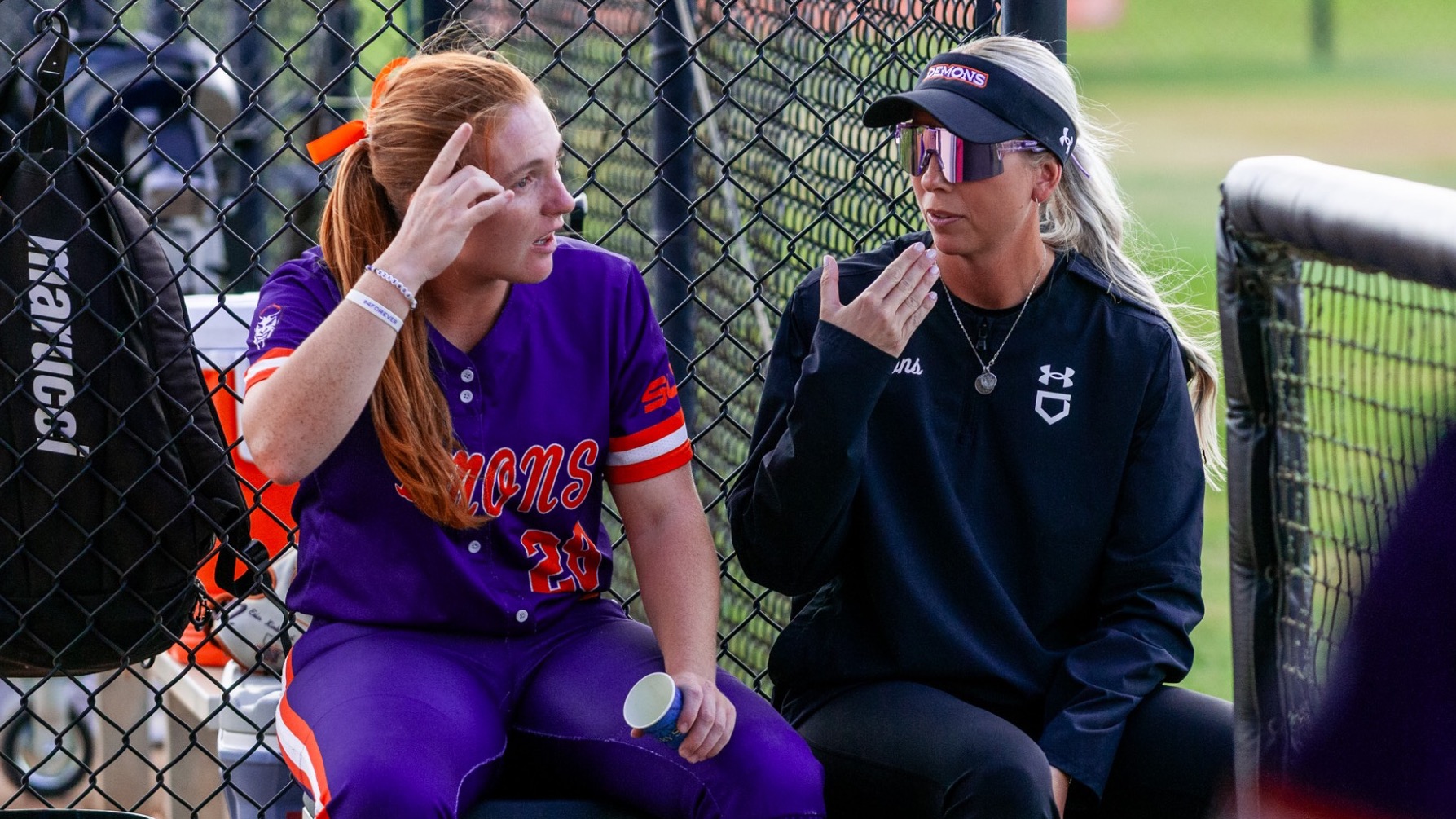 JT Smith and head coach Jenny Fuller sit and talk during a game.