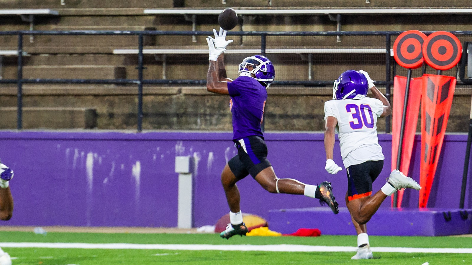 Camryn Davis catches a pass behind Troy Santa Marina during the first practice of fall camp.