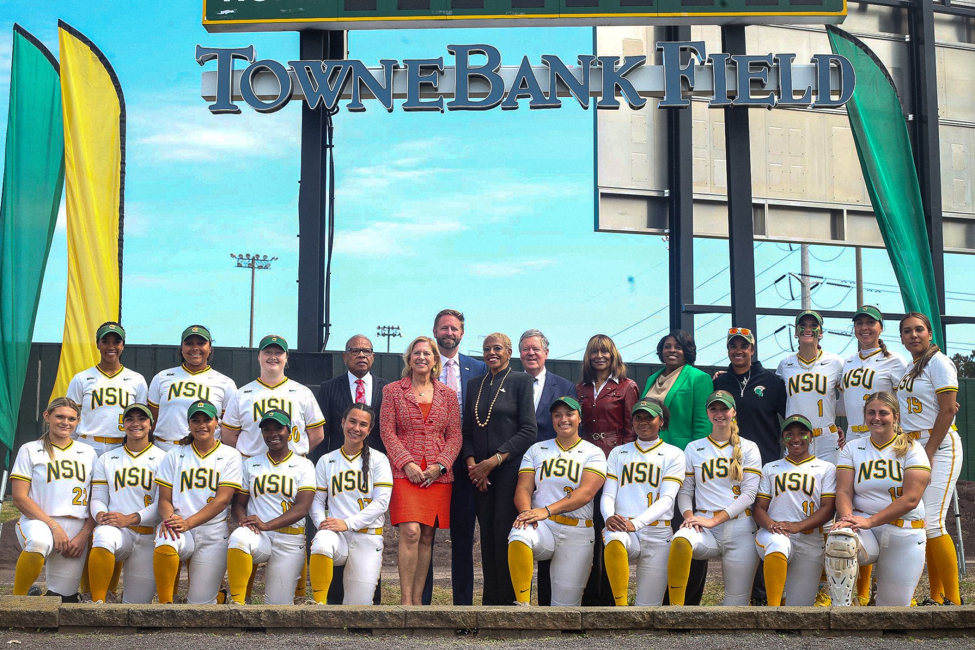 Administrators and softball team pose for a group picture.
