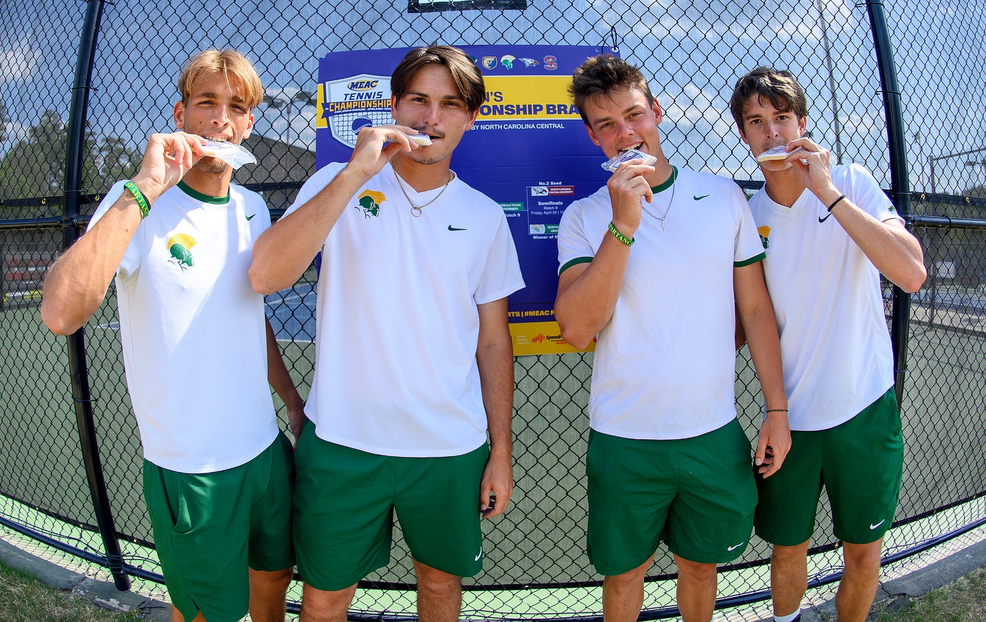 Men's Tennis celebrate semifinal win with cookies in front of bracket