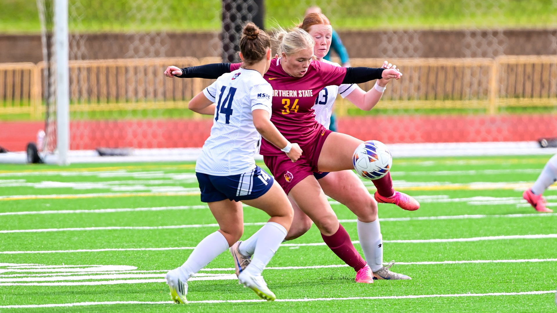 Northern State's Chloe Wallhead dribbling the soccer ball through UMary defenders.