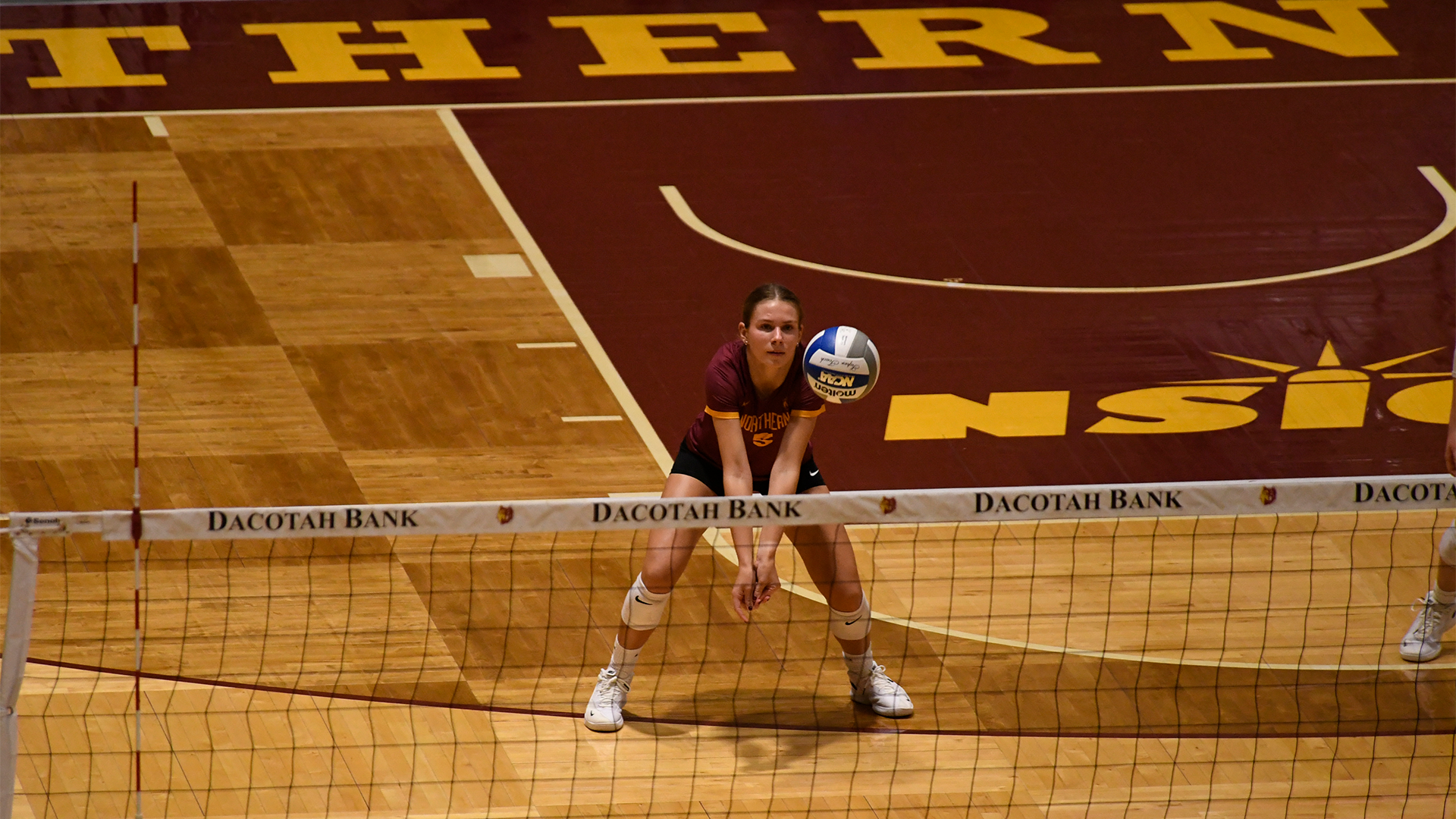 10.25 Volleyball Preview - Sara Moberg focuses on the ball for the dig with the Dacotah Bank net in front of her