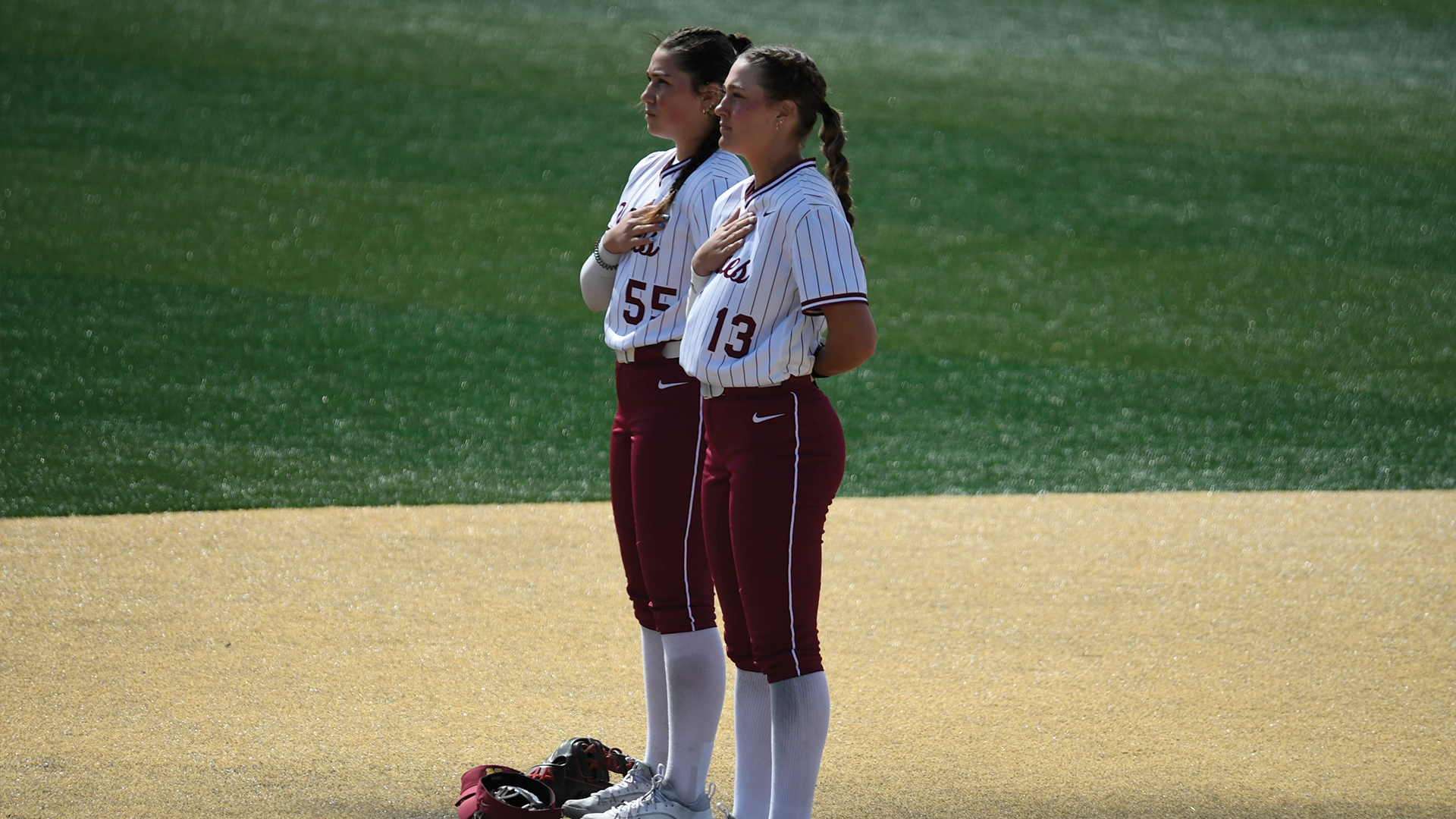 Alicia Jeanson (left) and Aune Boben (Right) stand at second base during the national anthem.