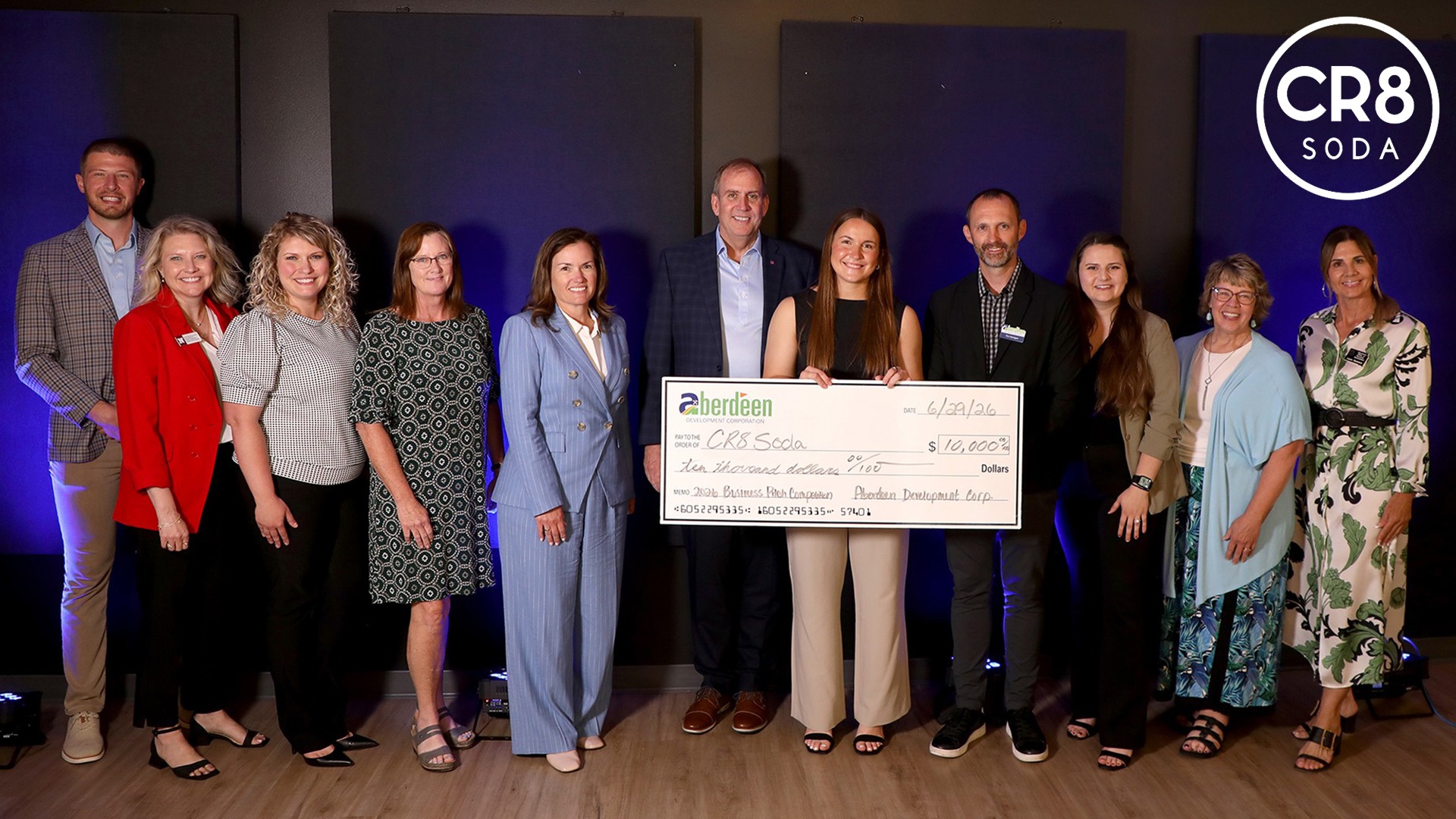 Madi Jones pictured with a $10,000 check for winning the Aberdeen Business Pitch Competition with members of the organization. 