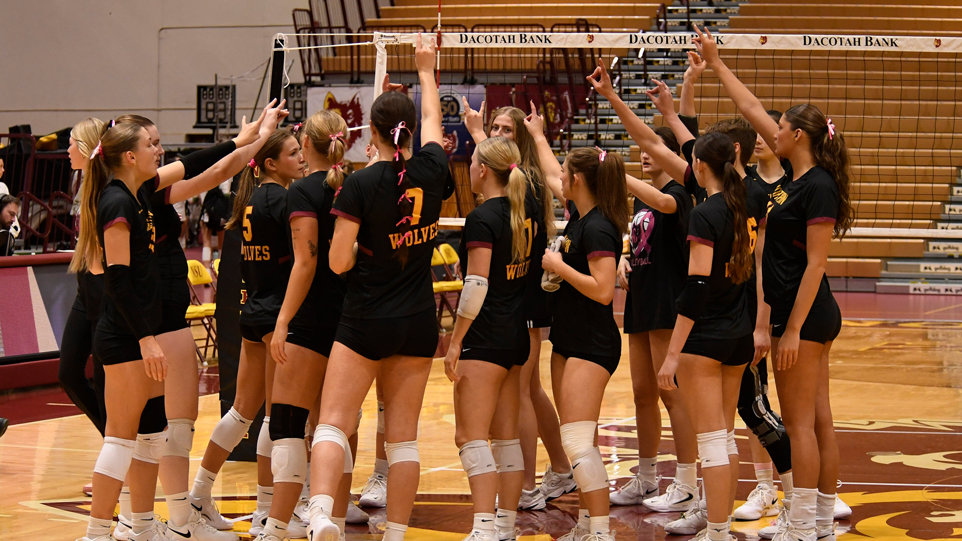 A picture of the 2025 NSU Volleyball team huddled together at the end of a match