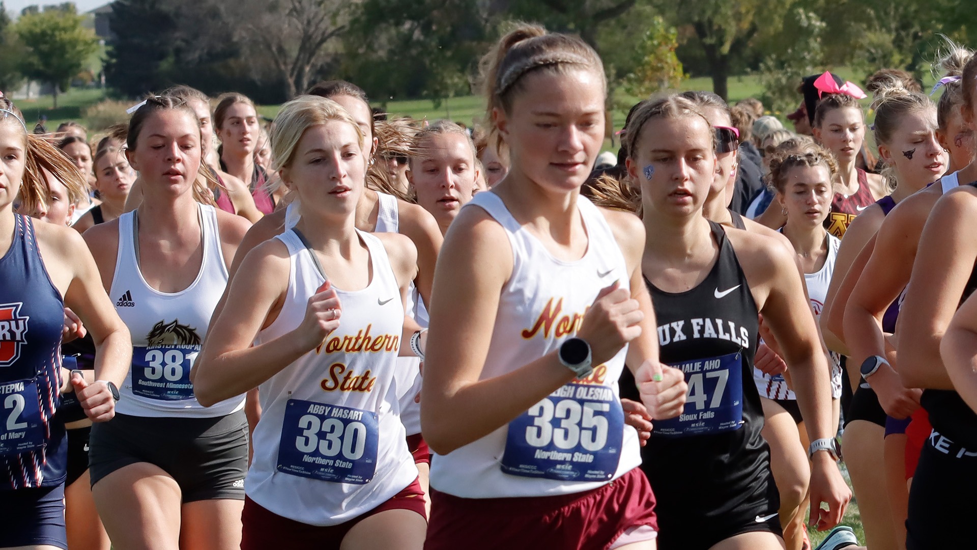 Olesiak and Hasart running in a crowd at the NSIC Championships