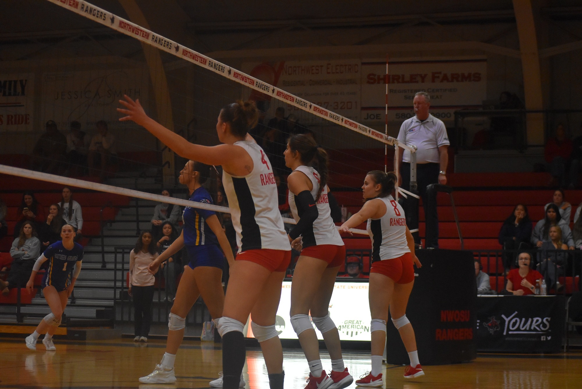 Volleyball players standing in front of net