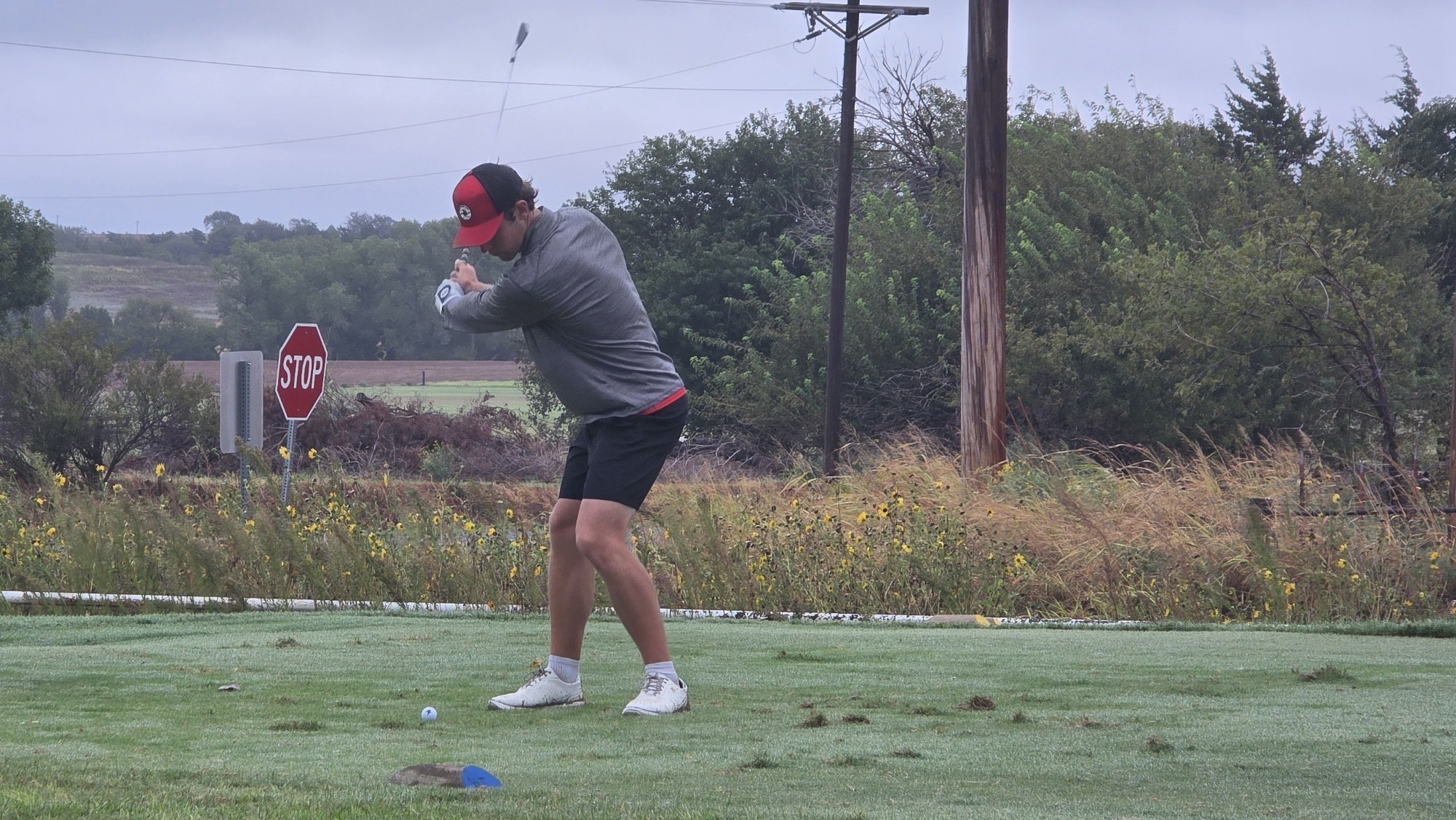 A member of the NWOSU men's golf team swings his club