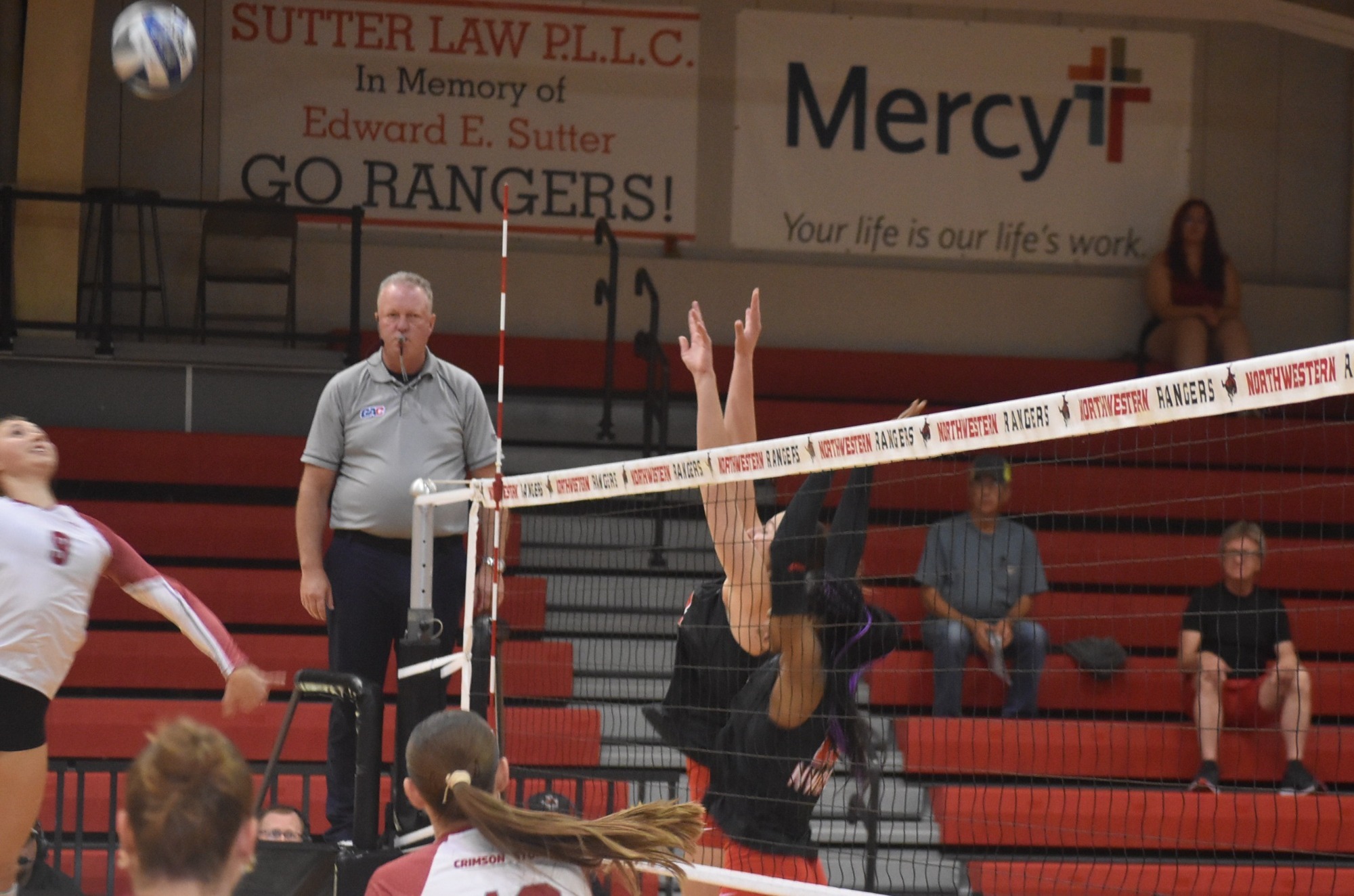Members of the Northwestern volleyball team jump to block the ball