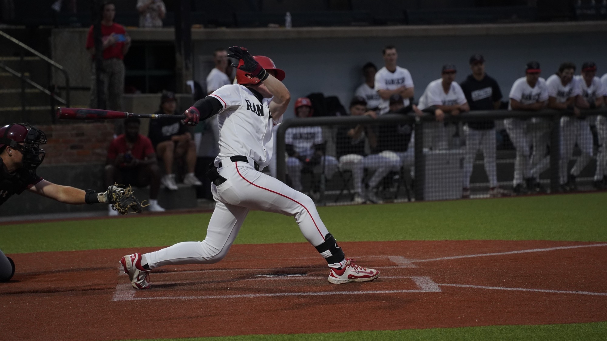 A Northwestern baseball player swings the bat.