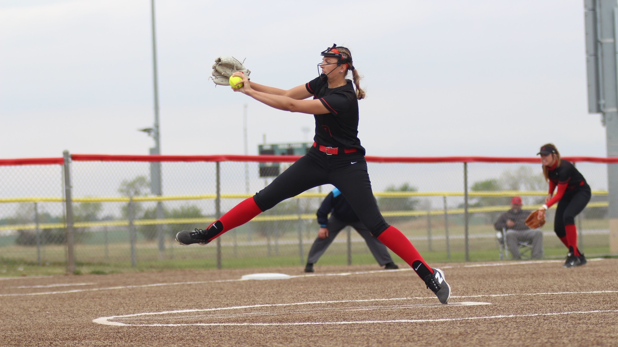Softball player pitching the ball