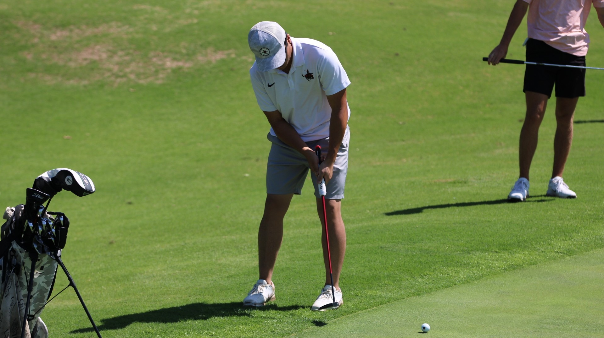 A member of the Northwestern golf team hits the ball.