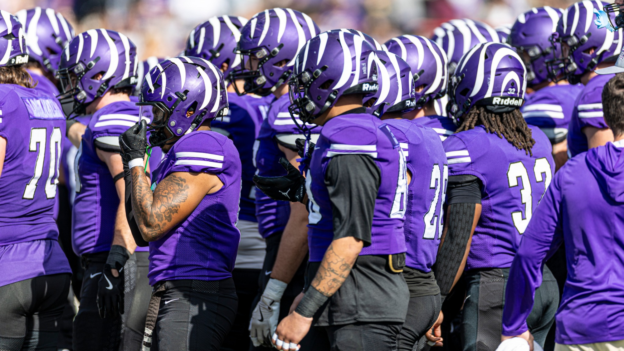 Football players huddle vs HSU 2025