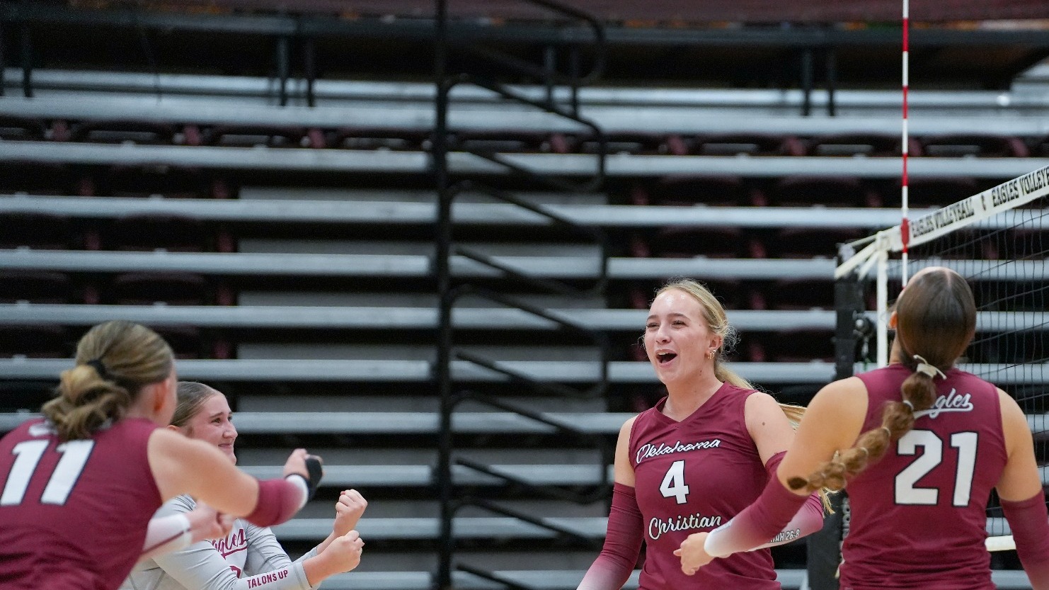 Oklahoma Christian volleyball player Molly Brunell (4) shouts in celebration surrounded by teammates Lauren Cary (21) and Kenzy McArtor (7) after winning a point near the net.