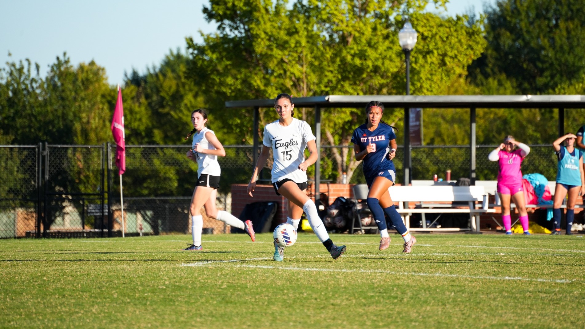A action shot of an Oklahoma Christian University women's soccer player (number 15) in a white 