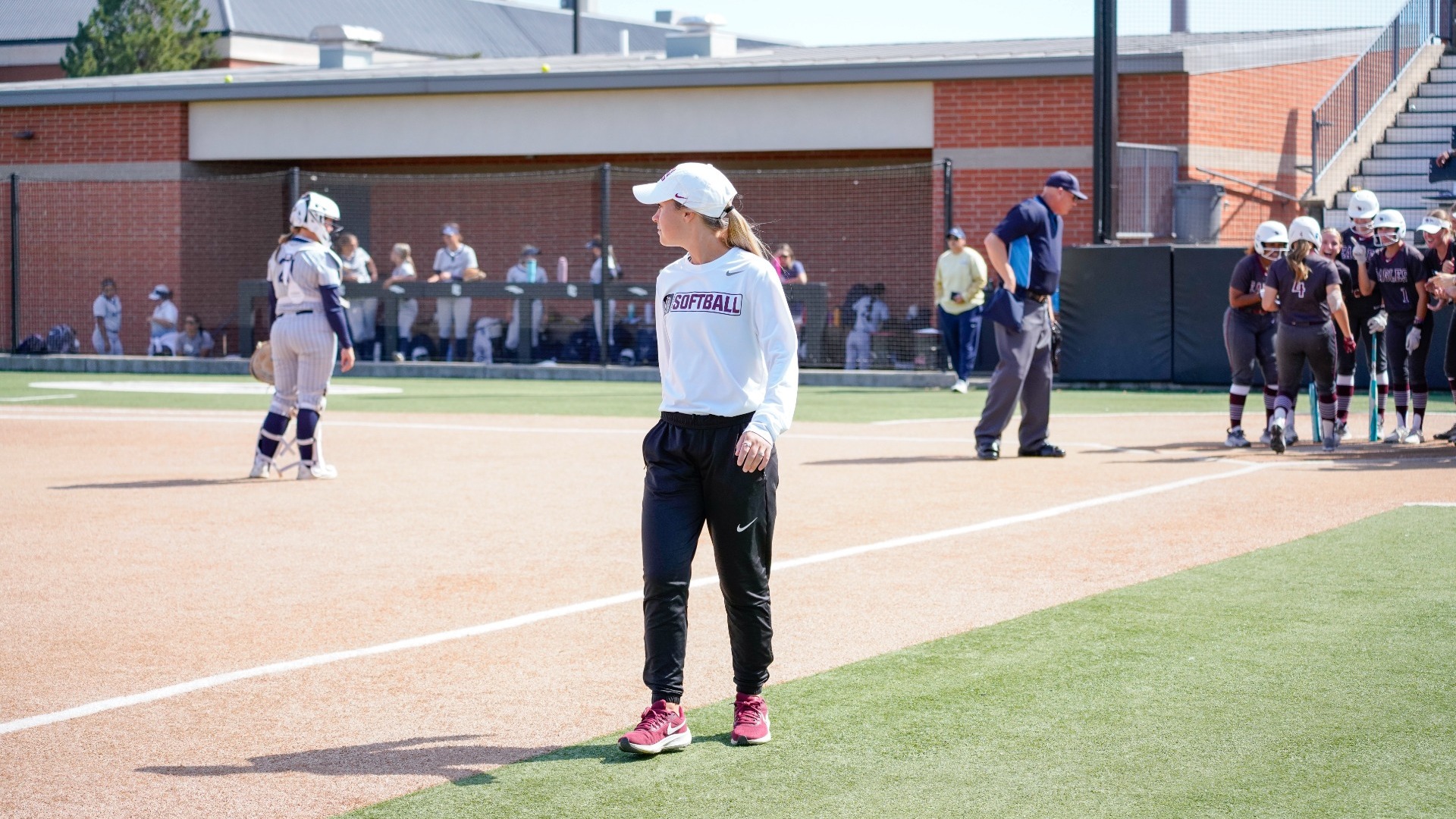 Coach Rodriguez as team celebrates home run in background