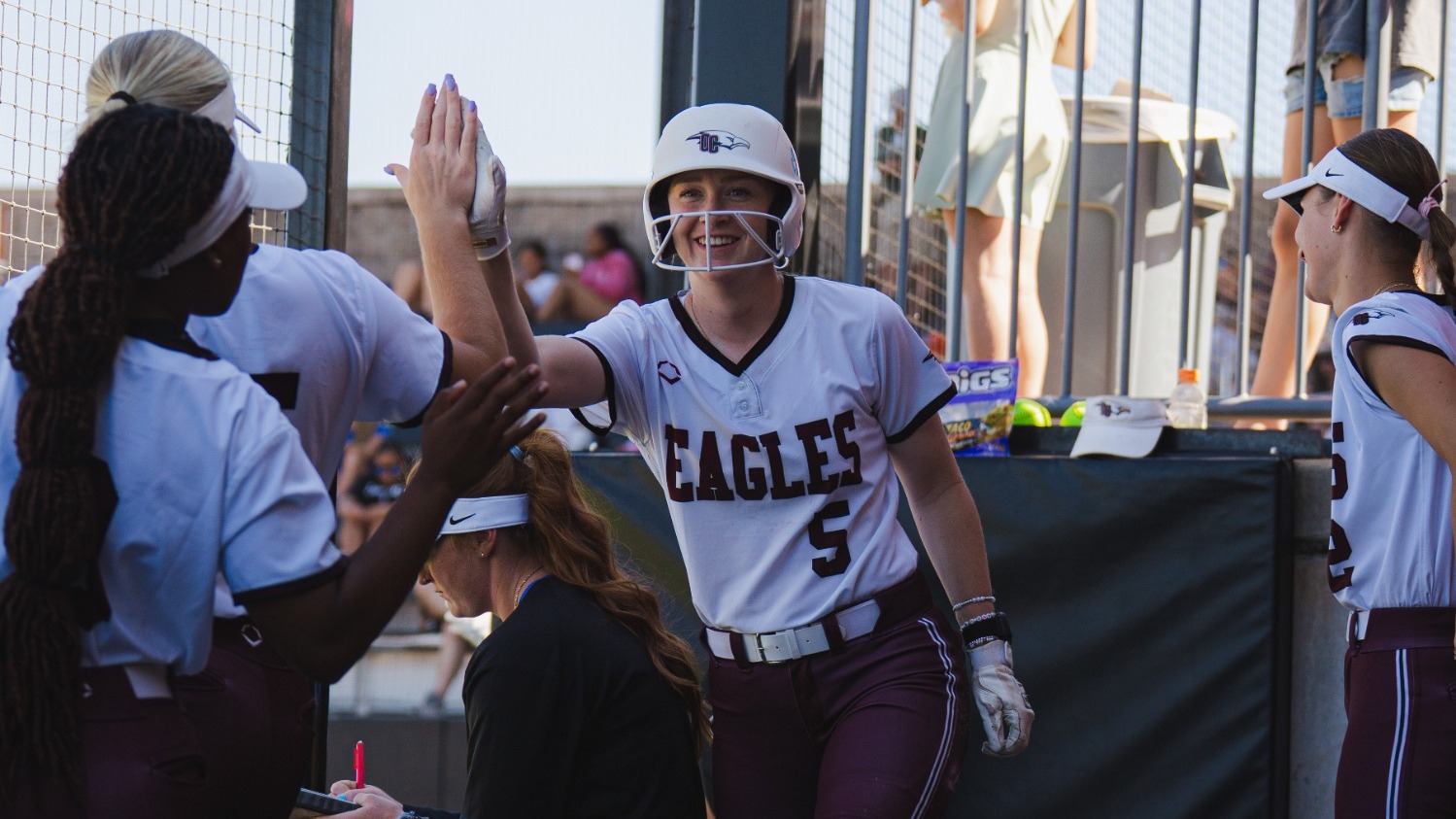 Kallie Rupp Celebrates in the dugout by high-fiving a teammate 