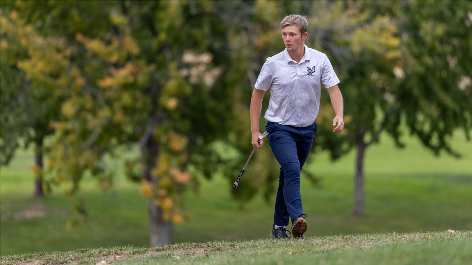 Golfer with putter walking
