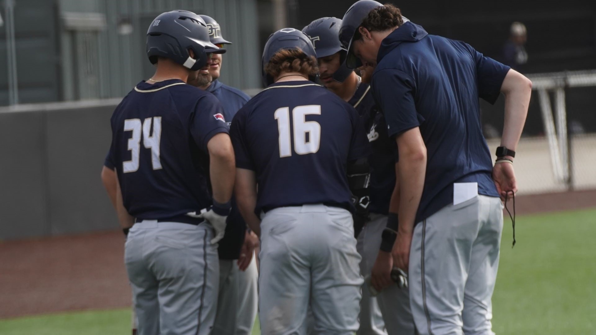 OIT Baseball Players Huddled at Third Base